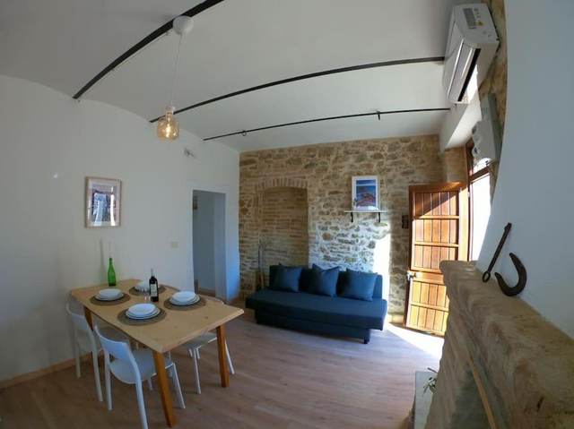 Living room with stone walls and fireplace at La Casetta del 1930